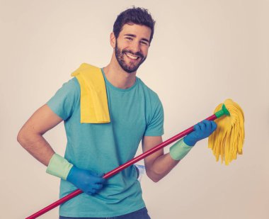 Cinsiyet klişelerini kırmak. Mutlu genç adam eğlenceli temizlik ve mikrofon şarkı ve dans gibi bir paspas tutarak ev işi yapıyor portresi. Toplumda kadın ve erkek rollerinin değişmesinde.