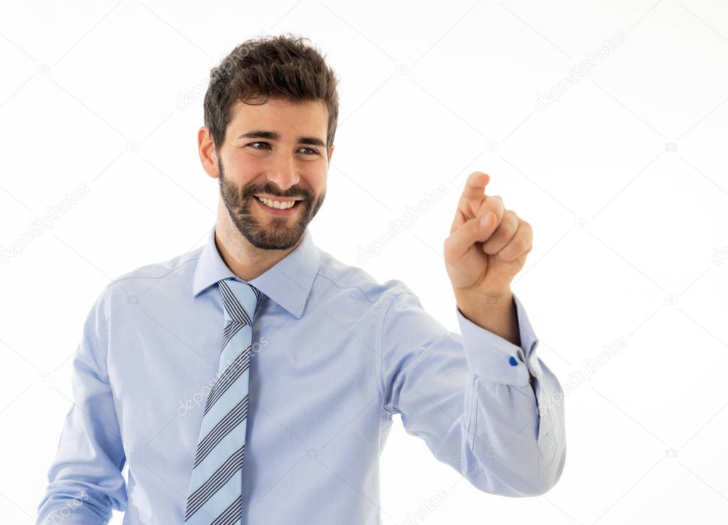 Young attractive businessman pointing at copy space as using a virtual screen. Smiling feeling confident and successful. In people business education, success and new technology at work concept.