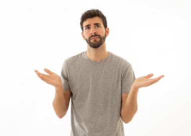 Çekici genç adam portresi hiçbir fikrim yok yüzünde belirsizlik ve habersiz ve sorgulanan bir görünüm ile el ele tutuşarak habersiz jest yapıyor. Beyaz arka planda izole edilmiş. İnsan ifadesi.