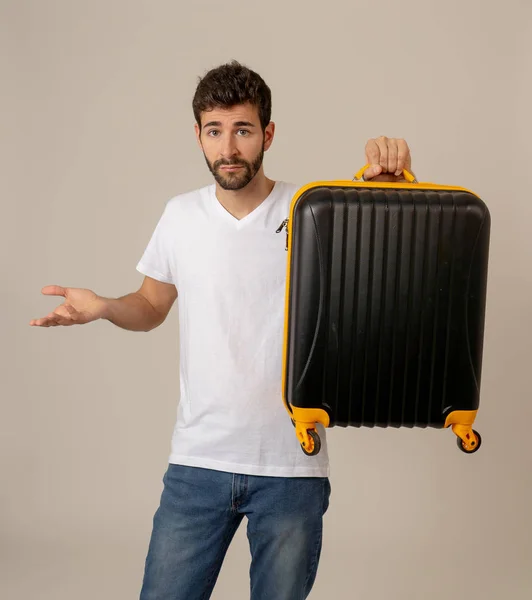 handsome young man with suitcase in studio