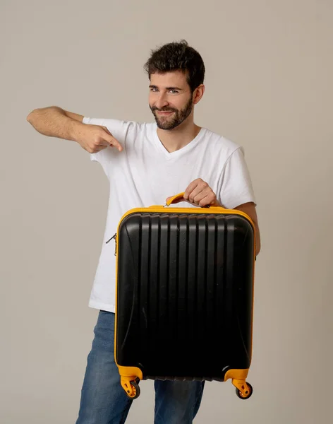 handsome young man with suitcase in studio