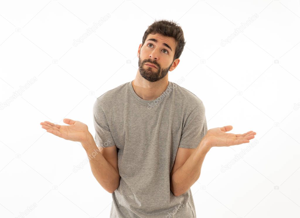 Portrait of Attractive young man making clueless gesture having no idea holding hands up with uncertainty on face and unaware and questioned look. Isolated on white background. Human expression.