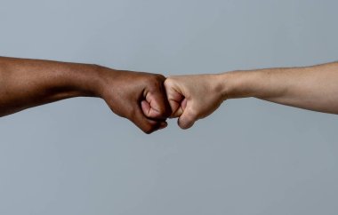 Siyah Afrikalı Amerikalı ırk erkek ve beyaz Kafkas kadın elleri anlaşma ortaklık ve işbirliği çok ırklı çeşitlilik ve göç kavramı bir yumruk yumru vererek. Irkçılığı durdurun kampanyası.