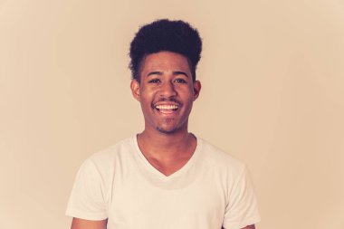 Mutlu Afro-Amerikan adam eğlenceli ve sevinç sahip portresi. Genç kameraya gülümseyerek ve onu güldüren bir şey arıyor. İnsan duygularında yüz ifadeleri ve gençlik mutluluğu.