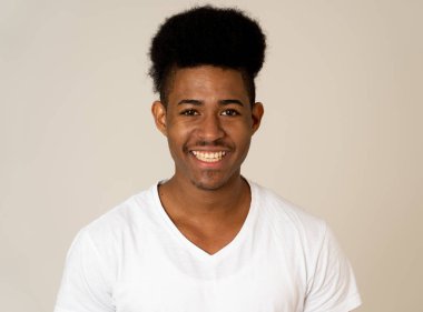 Mutlu Afro-Amerikan adam eğlenceli ve sevinç sahip portresi. Genç kameraya gülümseyerek ve onu güldüren bir şey arıyor. İnsan duygularında yüz ifadeleri ve gençlik mutluluğu.