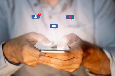 Sosyal medyada genç ya da yetişkin bir adamın yakını gibi sosyal ağ bildirim simgeleri ile akıllı telefon metin gönderme, mesaj, sevgi ve arkadaşlar. Bağlantılar ve Yeni teknoloji.