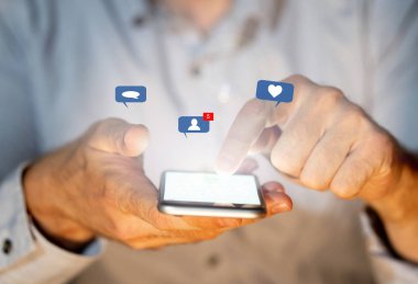 Sosyal medyada genç ya da yetişkin bir adamın yakını gibi sosyal ağ bildirim simgeleri ile akıllı telefon metin gönderme, mesaj, sevgi ve arkadaşlar. Bağlantılar ve Yeni teknoloji.