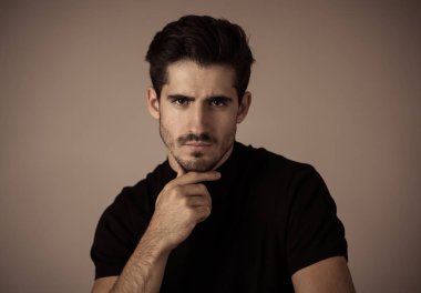 Yakışıklı, yakışıklı bir adamın portresi. Seksi ve şehvetli görünüyor. Güzel siyah evetler ve saçlar. İspanyol erkeksi pozunun stüdyo çekimi. Moda, doğal güzellik, modellik ve yaşam tarzı..