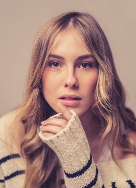 Mükemmel ciltli, uzun sarı saçlı, doğal ve güzel görünen genç bir kadının portresi. Moda, güzellik ve reklam konseptinde bir kadın modelin siyah beyaz moda stüdyosu görüntüsü.