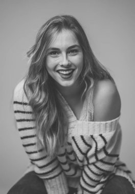 Mükemmel ciltli, uzun sarı saçlı, doğal ve güzel görünen genç bir kadının portresi. Moda, güzellik ve reklam konseptinde bir kadın modelin siyah beyaz moda stüdyosu görüntüsü.