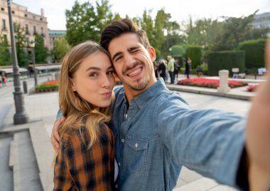 Güzel arkadaşlar, birbirine aşık turist çiftler gün batımında selfie çekerken Avrupa 'da bir şehri geziyorlar ve romantik bir tatil yapıyorlar. Turizm, seyahat yeri ve tatil konsepti.