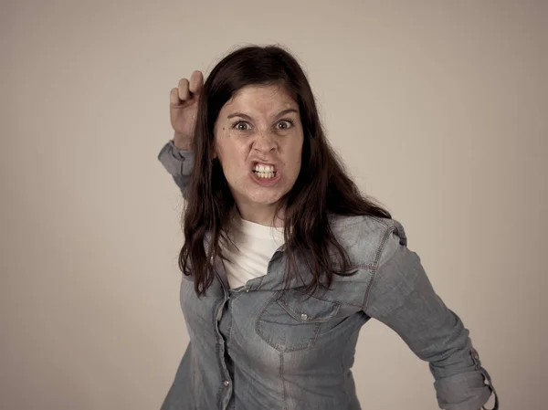 Facial expressions and emotions. Portrait of Young attractive caucasian woman with an angry glaring face. Looking mad and crazy shouting and making furious gestures. Isolated on neutral background.