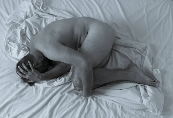 若い絶望的な裸の男だけで荒廃し 拒否感を泣いてベッドの上に横たわる 男性の精神衛生上の問題の概念的なイメージ うつ病 自殺や薬物中毒 — ストック写真
