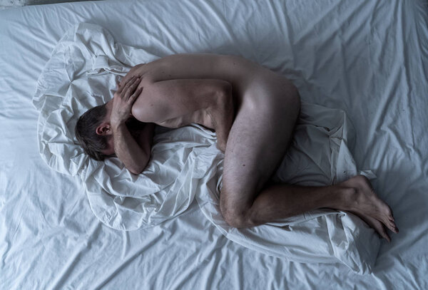 Сексуальное бессилие, вызванное курением сигарет в рекламном имидже против табака. Молодой отчаянный грустный голый мужчина лежит на кровати плачет в одиночестве чувство стыда и опустошенных страданий эректильной дисфункции
.