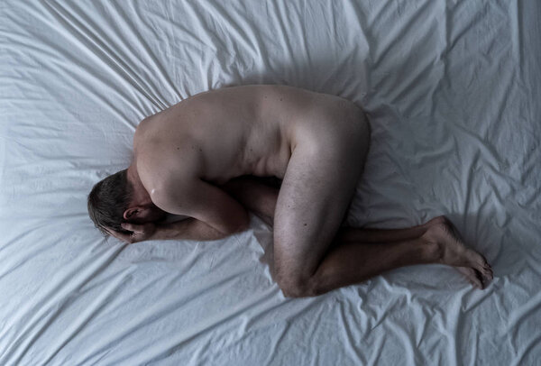 Сексуальное бессилие, вызванное курением сигарет в рекламном имидже против табака. Молодой отчаянный грустный голый мужчина лежит на кровати плачет в одиночестве чувство стыда и опустошенных страданий эректильной дисфункции
.