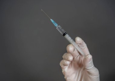 COVID-19 Coronavirus aşısı. Sars-CoV-2 virüsünü inceleyen şırıngalı bir bilim adamı aşı araştırması için klinik deneylere hazır. Kadın araştırmacı laboratuarda potansiyel aşıyı test ediyor..