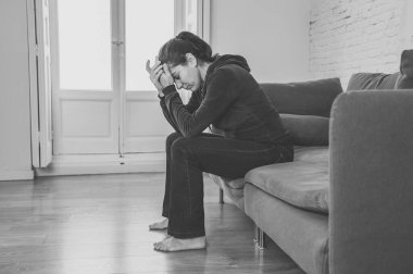 Yalnız ve çekici Latin bir kadın kanepesinde ağlıyor üzgün, yorgun ve endişeli evde yalnız başına depresyon geçiriyor. Akıl sağlığı ve tecrit, stres, işsizlik ve kalp kırıklığı kavramı.