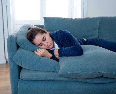 Yalnız ve çekici Latin bir kadın kanepesinde ağlıyor üzgün, yorgun ve endişeli evde yalnız başına depresyon geçiriyor. Akıl sağlığı ve tecrit, stres, işsizlik ve kalp kırıklığı kavramı.