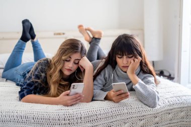 COVID 19 Salgını. Karantina sırasında evde cep telefonu kullanan depresif ev arkadaşları. Coronavirus tecridi ve sosyal uzaklık süresince ruh sağlığına etkisi.