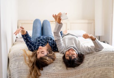 COVID-19 tecrit. Coronavirus sosyal mesafesi ve karantinası sırasında cep telefonuyla online müzik dinleyen kendinden emin ve pozitif kadın sevgililerin portresi. Evde kal, sağlıklı kal..