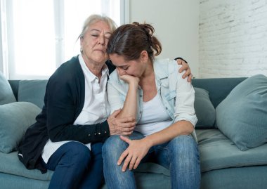 Yaşlı anne, Coronavirus 'la savaşan sevdiğinin yasını tutan yetişkin kızını teselli ediyor. Yaşlı anne depresyondan muzdarip yetişkin kızını kucaklıyor. COVID-19 salgınından etkilenenler.