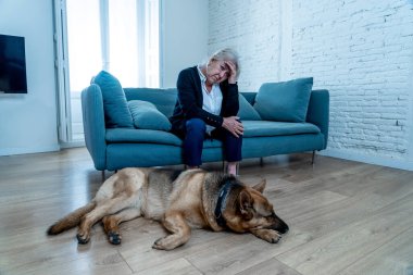 Bunalımlı yaşlı kadın evcil bir köpekle kanepede ağlıyordu. COVID-19 salgınının ortasında üzgün ve yorgun bir dul. Coronavirus ölümü, tecrit, sosyal uzaklık ve zihinsel sağlık.