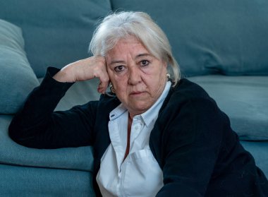 Yalnız, yaşlı, bunalımlı, dul bir kadın evde karantinada, üzgün ve endişeli bir şekilde ağlıyor. Kocası ve ailesi kayıp, COVID-19 salgını, tecrit, sosyal mesafeler ve zihinsel sağlık sorunları yaşıyor..