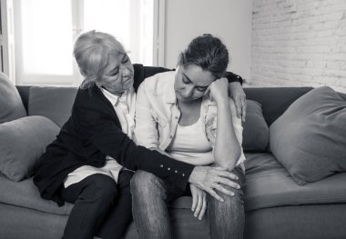 Yaşlı anne, Coronavirus 'la savaşan sevdiğinin yasını tutan yetişkin kızını teselli ediyor. Yaşlı anne depresyondan muzdarip yetişkin kızını kucaklıyor. COVID-19 salgınından etkilenenler.