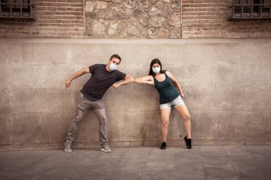 Yeni Normal ve selamlama tarzı. Erkek ve kadın, Coronavirus 'un yayılmasını önlemek için dirseklerini ya da ayaklarını sallayarak sosyal mesafeyi koruyorlar. COVID-19 salgını ve hastalık koruması.