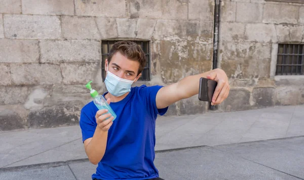 Νεαρός Άνδρας Στο Δρόμο Της Πόλης Προστατευτική Μάσκα Χρησιμοποιώντας Απολυμαντικό — Φωτογραφία Αρχείου