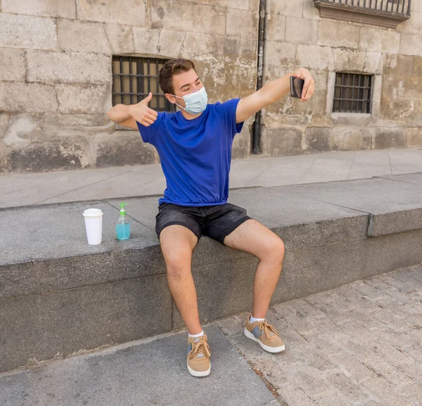 Νεαρός Άνδρας Στο Δρόμο Της Πόλης Προστατευτική Μάσκα Χρησιμοποιώντας Απολυμαντικό — Φωτογραφία Αρχείου