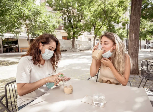 Vriendinnen Koffieshop Dragen Een Beschermend Gezicht Masker Met Handreiniger Vrouwen — Stockfoto