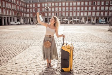 Korunaklı yüz maskesi takan genç turist kadın Coronavirus salgını sonrası İspanya Plaza Belediye Başkanı Madrid 'de mutlu ve heyecanlı bir şekilde Avrupa' da tatilin tadını çıkarıyor. COVID-19 Yeni Normal ve Seyahat.