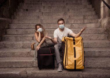 COVID-19 'un uluslararası turizm üzerindeki etkisi. Üzgün turist çift, yeni seyahat yönetmeliklerinin ortasında Coronavirus karantinasından endişeli. Coronavirüs seyahat kısıtlamaları nedeniyle tatiller iptal edildi.