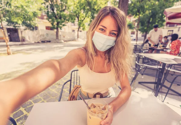 Ung Kvinna Med Skyddsmask Och Handdesinfektionsmedel Videosamtal Med Mobiltelefon Caféet — Stockfoto