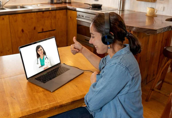 COVID-19 Online medical consultation. Woman in virtual appointment with online female doctor getting health advice and medical care from home in Coronavirus pandemic lockdown and social distancing.