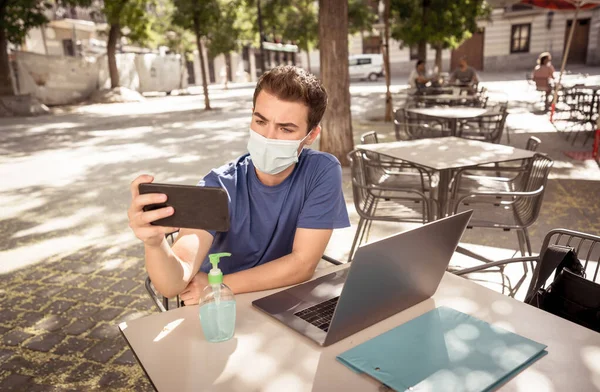 Jovem Vestindo Máscara Protetora Usando Celular Videoconferência Trabalhando Remotamente Laptop — Fotografia de Stock