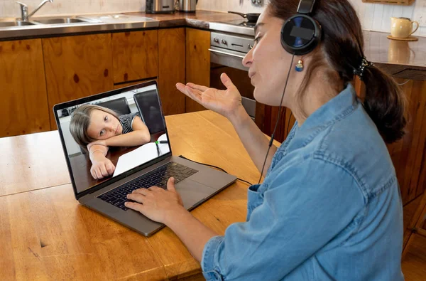 Teacher on virtual call to student young child with face mask in self isolation after being tested positive for COVID-19. Reopening of Schools and Second COVID-19 Outbreak wave and online learning.