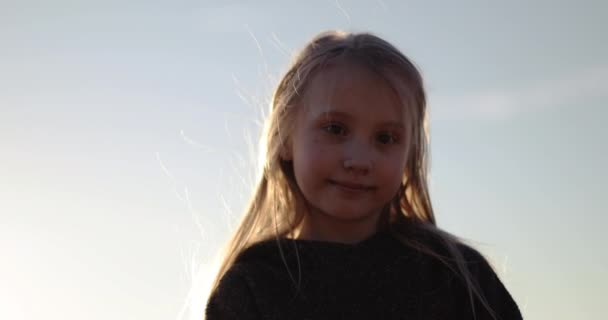 Porträt eines süßen Mädchens bei Sonnenuntergang. — Stockvideo