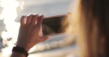 Annem dans eden bir kızın cep telefonuyla video çekiyor.