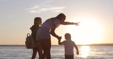 Mutlu bir aile göl kıyısında yürür..