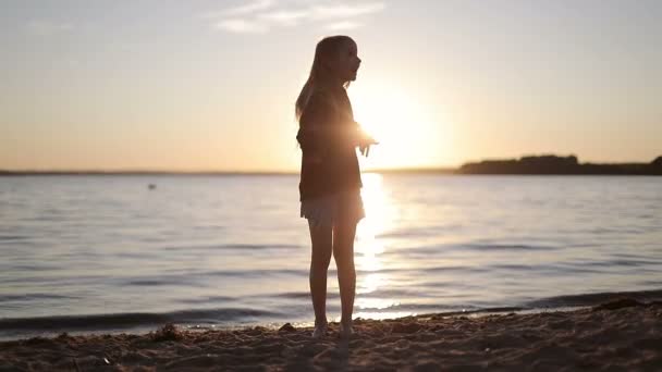 Estudante alegre está dançando no lago ao pôr do sol . — Vídeo de Stock