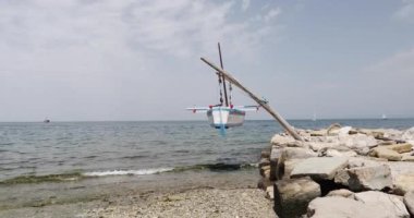 Kürekli bir balıkçı teknesi iskelede asılı duruyor..
