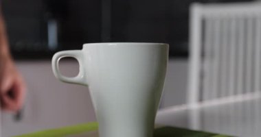 Adam sabahları iki fincan çay ya da kahve yapıyor..