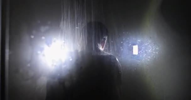 Water jets and drops glow in the backlight. — Stockvideo