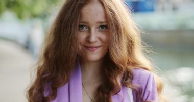 Mutlu kız portresi, uzun kızıl saçlı yaz parkında gün batımında..