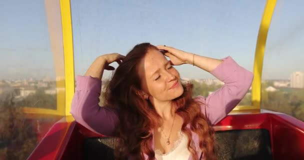 Mladá žena model s přírodními pihami upravující vlasy v jasném slunečním světle. — Stock video