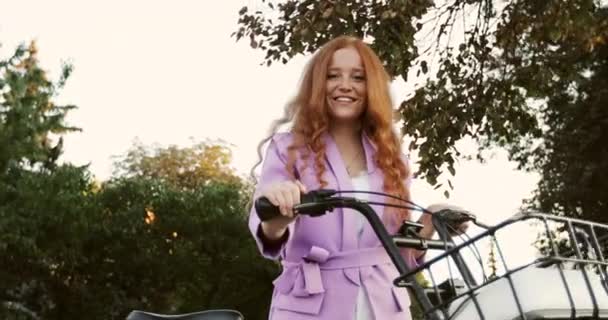 Redhead κορίτσι με φακίδες βόλτες με ένα ποδήλατο πόλης με ένα καλάθι. — Αρχείο Βίντεο