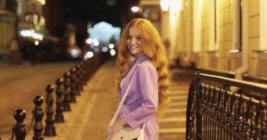 Çilli kızıl saçlı kız kameraya bakıp gülümsüyor..