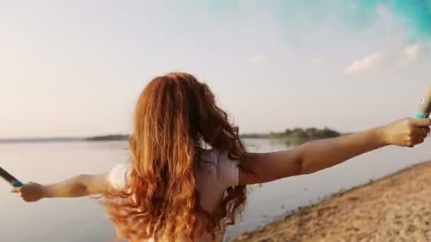 Mavi renkli dumanlı, çilli kızıl saçlı kız nehir kıyısında koşuyor. — Stok video